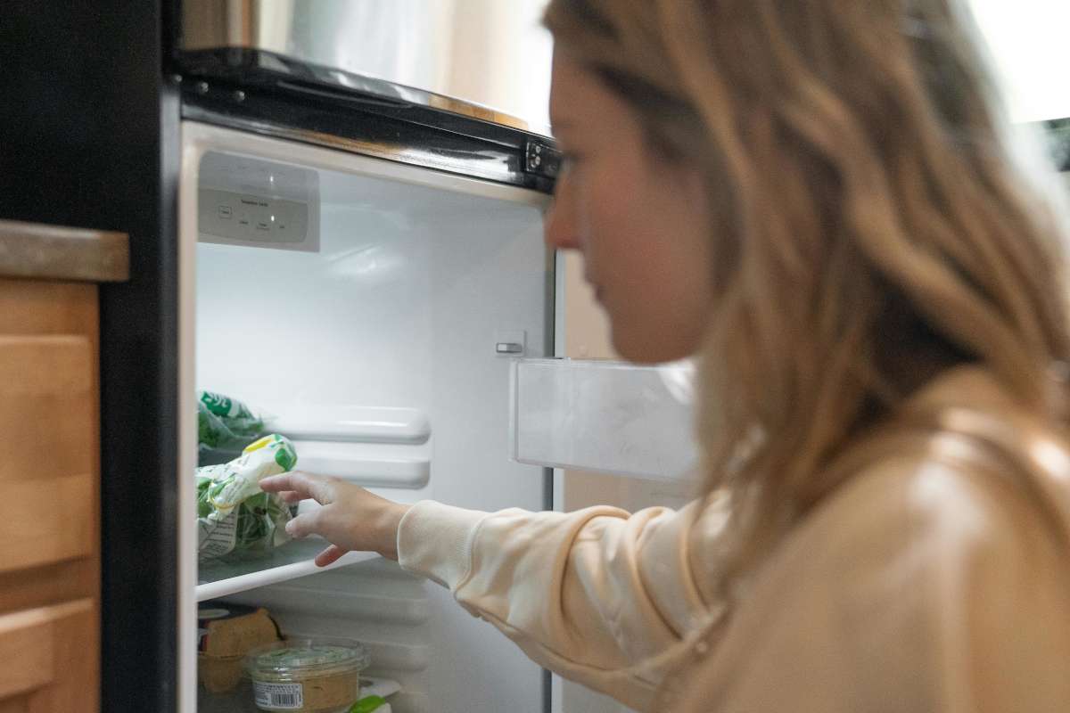 Ragazza che prende cose dal frigorifero